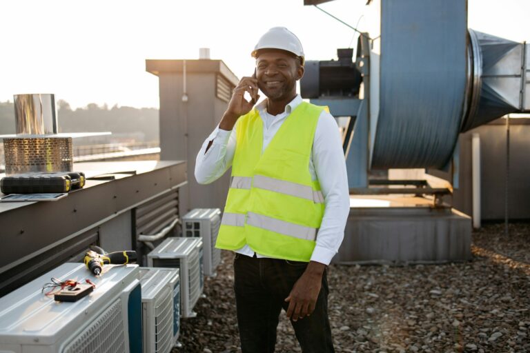 Man engineer standing and talking on smartphone on roof